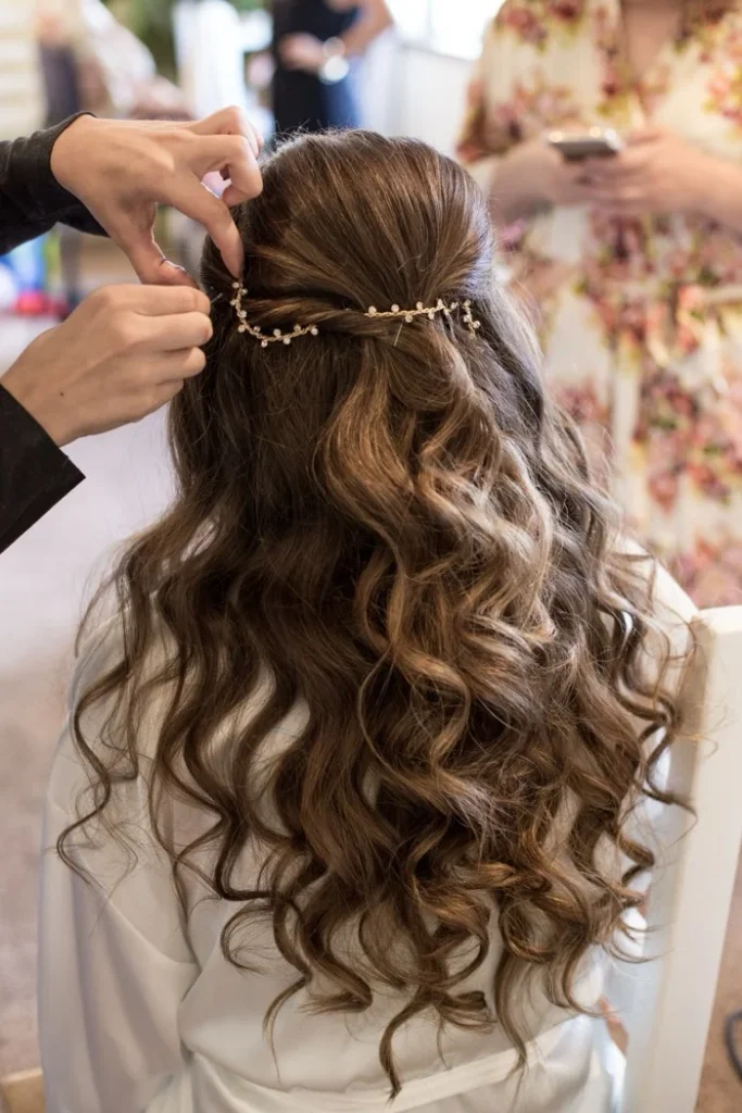 Hairstylist perfecting an intricate bridal updo decorated with floral pearl hair accessories at RH Beauty Lounge in Las Vegas