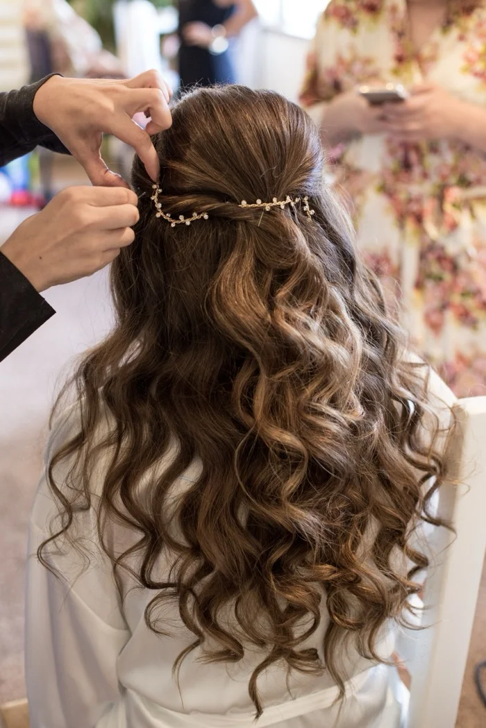 Hairstylist perfecting an intricate bridal updo decorated with floral pearl hair accessories at RH Beauty Lounge in Las Vegas