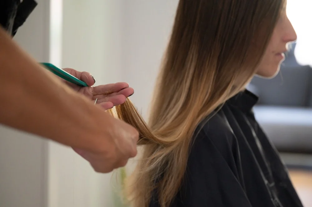 stylist applying keratin treatment to clients hair in salon