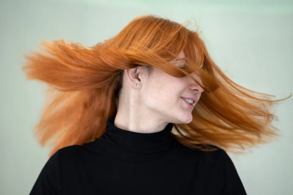 Vibrant copper ginger hair color with warm undertones for spring 2026